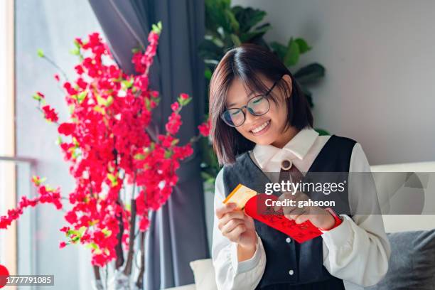 teenage girl opening red envelope chinese new year - chinese new year red envelope stock pictures, royalty-free photos & images