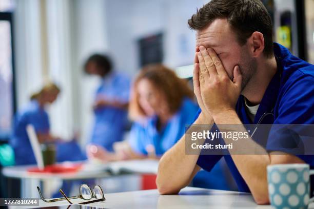 stressed young doctor - nhs stock pictures, royalty-free photos & images