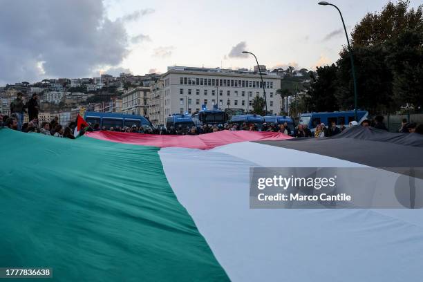People with a giant flag, during the demonstration in Naples in solidarity with the Palestinian people after Israel's attacks on the Gaza strip, near...