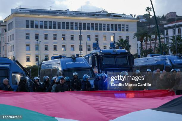 The police lined up to protect the US consulate in front of a giant Palestinian flag, during the demonstration in Naples in solidarity with the...