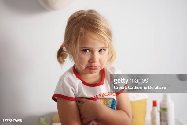 a 3 year old little girl sulking, with arms crossed - blonde fille photos et images de collection