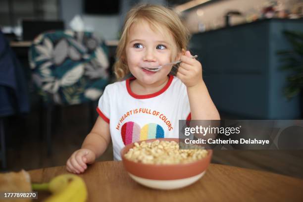 a 3 year old little girl having her breakfast at home - bestick bildbanksfoton och bilder
