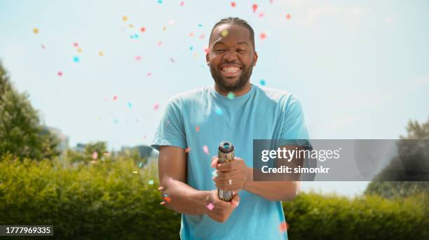 man exploding confetti - party popper stock pictures, royalty-free photos & images