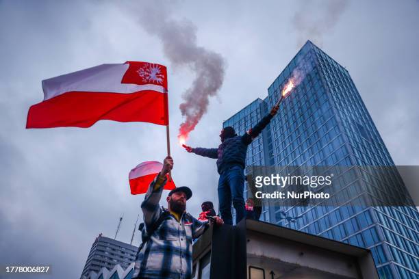 Participants hold flags and flares during 'The Independence March' organized by far right supporters and nationalist groups to celebrate the 105th...