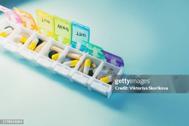 weekly pillbox with medication, conceptual image, horizontal composition - opening week stock pictures, royalty-free photos & images