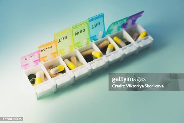 weekly pillbox with medication, conceptual image, horizontal composition - weekly stock pictures, royalty-free photos & images