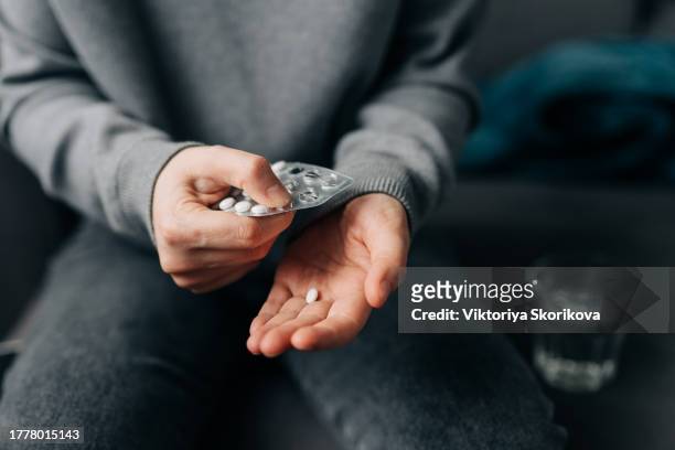 female hands with pills on background of water glass with effervescent tablet. soluble drug.take medicine, vitamins. - levend organisme stockfoto's en -beelden