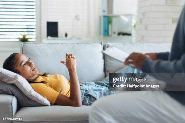 psychological session or therapy for teenage girl with adolescent psychologist. teenager talking with therapist. concept of teen mental health and unique adolescent behaviour, problems. - psychiatercouch stock-fotos und bilder