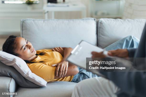 psychological session or therapy for teenage girl with adolescent psychologist, therapist. concept of teen mental health and unique adolescent behaviour, problems. - stemmingswisseling stockfoto's en -beelden