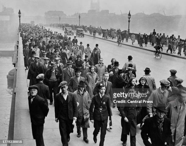 Crowd of commuters make their way across the London Bridge as they make their way into the City of London, England, 1937.