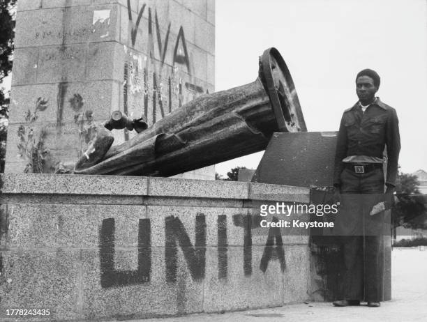 Man stands beside one of the Portuguese colonial statues pulled down by UNITA during the Angolan Civil War, in Nova Lisboa , Angola, 12th November...