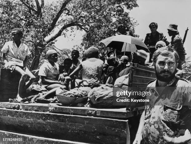 Angolan refugees are brought into the refugee centre by South African troops in a military truck during the Angolan Civil War, in Ovambo, Angola,...