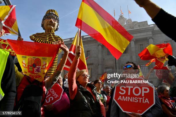 Demonstrators hold a figure depicting Catalan leader Carles Puigdemont next to 'Stop Amnesty' signs and Spanish flags during a protest called by...