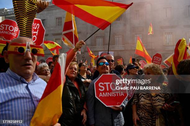 Demonstrators hold 'Stop Amnesty' signs and Spanish flags during a protest called by right-wing opposition against an amnesty bill for people...