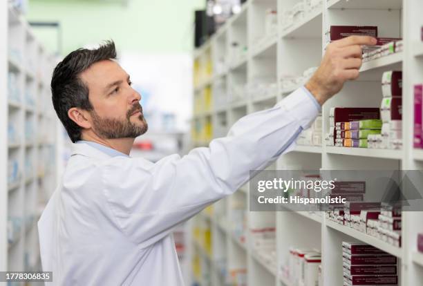 pharmacist looking for prescription medicines at the drugstore - kabinet dokter stockfoto's en -beelden