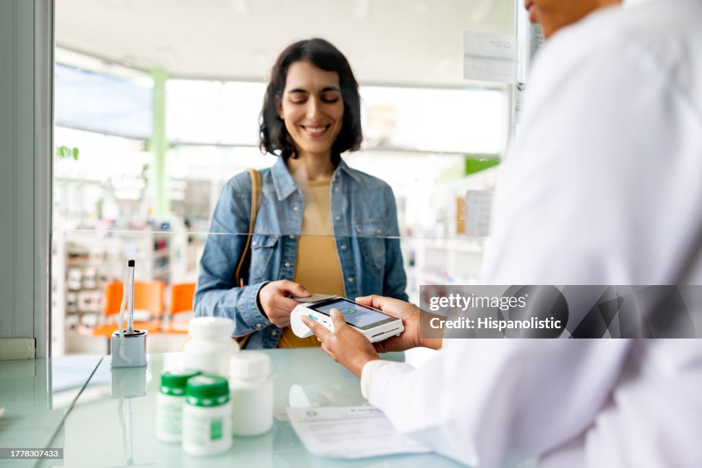 Woman paying by card while buying medicines at the pharmacy