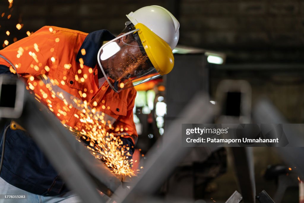Skilled worker crafts steel with precision and dedication. As a shower of sparks flies in all directions, it illuminates a scene of metalworking artistry, a sparks and steel. Craftsman in protective gear operates an angle grinder with unwavering skill.