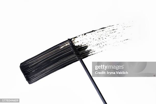 flying waved black smear of black eye liner from a mascara brush on white background, isolated. cosmetic make-up product for eyelashes. - smudged stock pictures, royalty-free photos & images