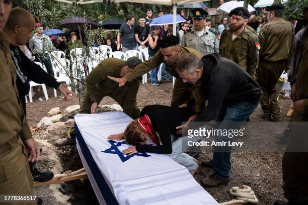 Family and friends mourn during the funeral of fallen soldier, staff Sgt. Gilad Rozenblit, killed in the Gaza Strip on November 12, 2023 in Ginegar,...