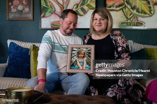 Jesse and Megan Parks hold a photo of their 2-year-old daughter Kennedy, who passed away after contracting the flu.