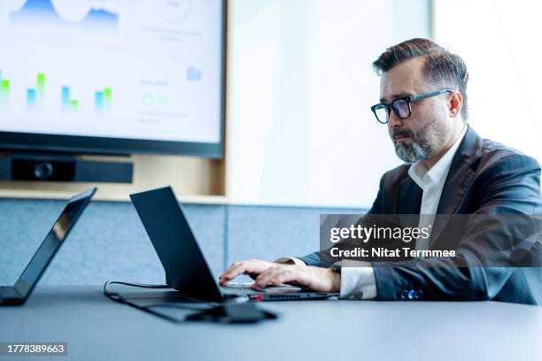 focused vision sustainability in business as a key factor to success. business executive viewing data for a business management review meeting over a laptop computer in a meeting room. - cfo stock pictures, royalty-free photos & images