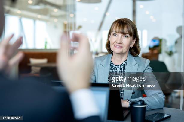 building strong business relationships with face-to-face meetings. senior businesswoman having a meeting with her business partner for an investment in a new business. - cfo stock pictures, royalty-free photos & images
