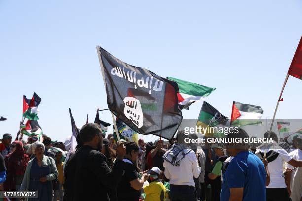 Man holds an ISIS flag as pro-Palestinian supporters gather in Cape Town on November 12 after pro-Israeli supporters were chased away by them while...
