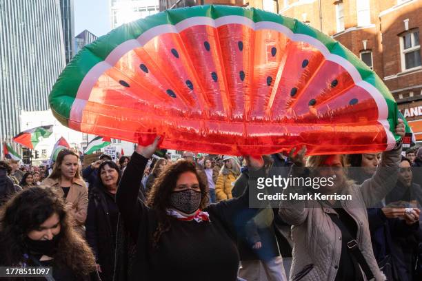 Pro-Palestinian protesters holding an inflatable water melon, a symbol of resistance in occupied Palestine, take part in an Armistice Day march from...