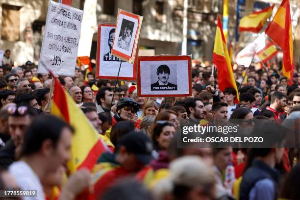 Demonstrators hold signs and Spain's flags during a protest called by right-wing opposition against an amnesty bill for people involved with...