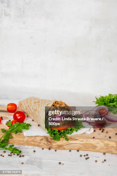 close-up of food on cutting board against wall - döner stock-fotos und bilder