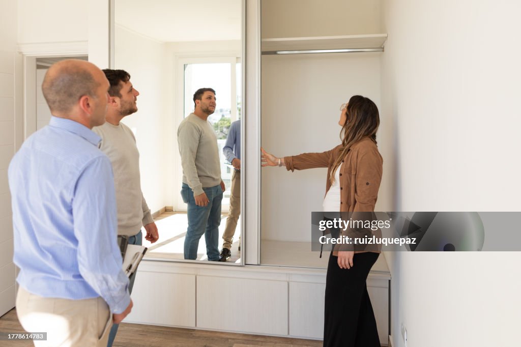 Real estate agent and young couple in new home
