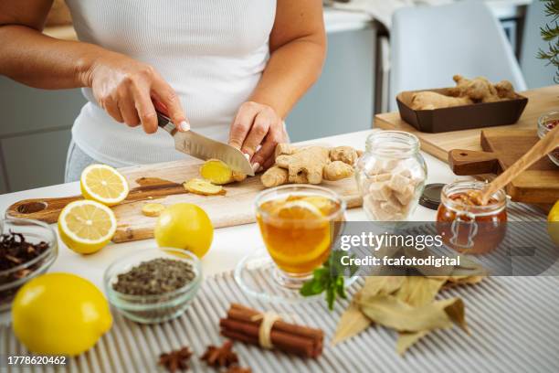 woman preparing healthy ginger and lemon tea - knife kitchen stock pictures, royalty-free photos & images