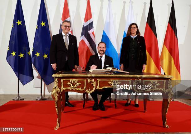 Haakon Crown Prince Of Norway , beside of Bavarian ministers Florian Herrmann and Ilse Aigner signs the guest book of the Bavarian state government...