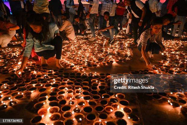 People light earthen lamps on the banks of Saryu River during a cultural programme, on the eve of Diwali festival, on November 11 Ayodhya, India....