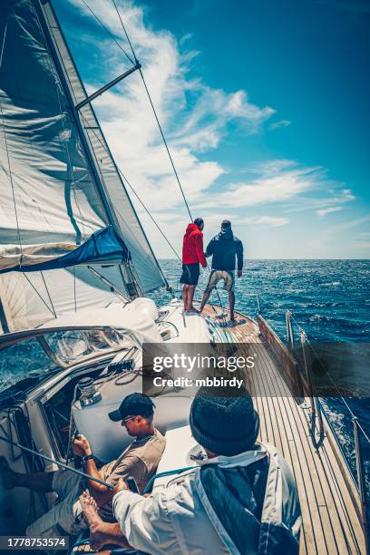 crew members sailing on sailboat on sunny day - sailing competition stock pictures, royalty-free photos & images