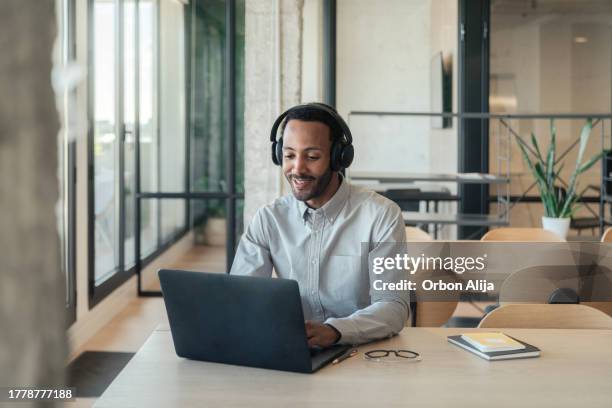hombre hispano trabajando en su computadora portátil - videoconferencia fotografías e imágenes de stock