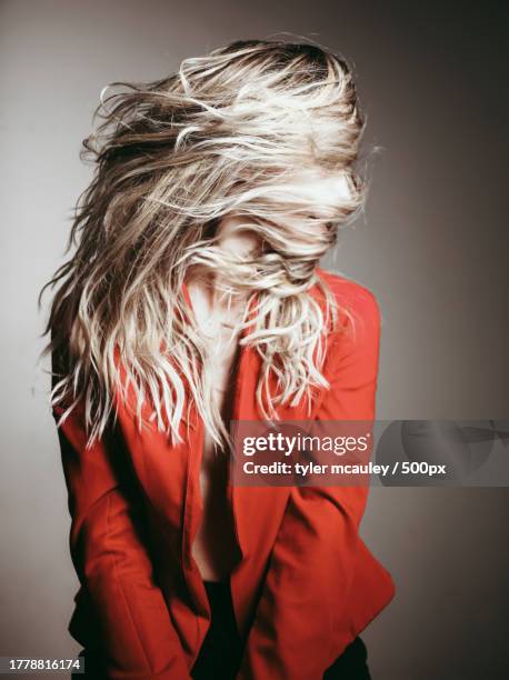 portrait of woman turning her head away wearing red costume against gray background,chicago,illinois,united states,usa - editorial woman stock pictures, royalty-free photos & images