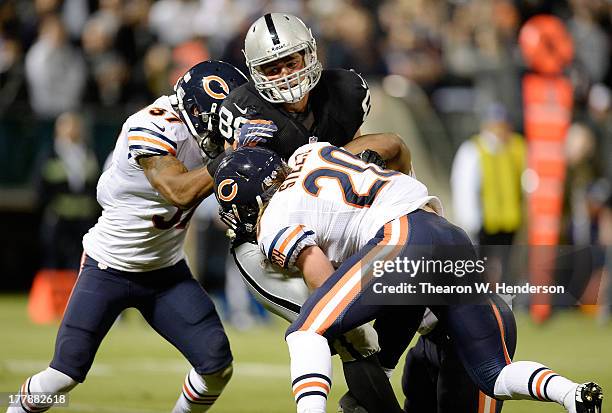 Nick Kasa fo the Oakland Raiders catches a nineteen yard touchdown pass dragging Jonathan Bostic, Craig Steltz and Anthony Walters of the Chicago...