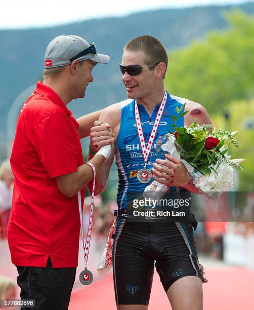 Jeff Symonds is congratulated by Challenge Family CEO Felix Walchshofer after winning the men's division of the Challenge Penticton Triathlon on...