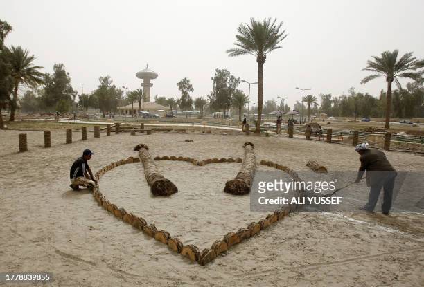 Iraqi agriculture workers prepare flower gardens ahead of an international flower exhibition at Baghdad's popular Zawra public park on March 24,...