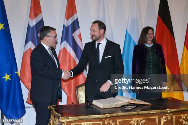 Haakon Crown Prince Of Norway shakes hands with Bavarian ministers Florian Herrmann, beside of Ilse Aigner after signing the guest book of the...