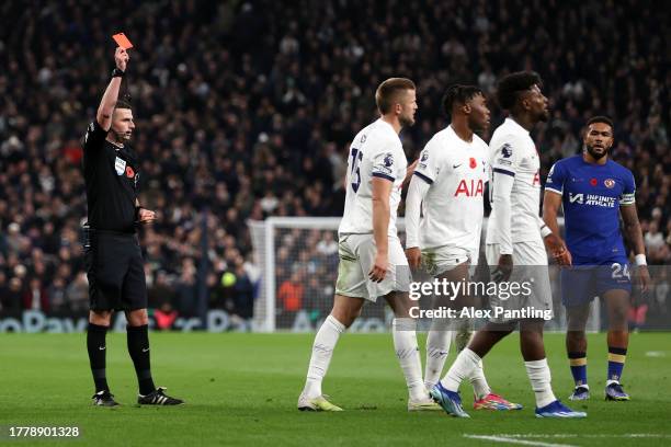 Referee Michael Oliver shows a red card to Destiny Udogie of Tottenham Hotspur after a foul on Raheem Sterling of Chelsea during the Premier League...