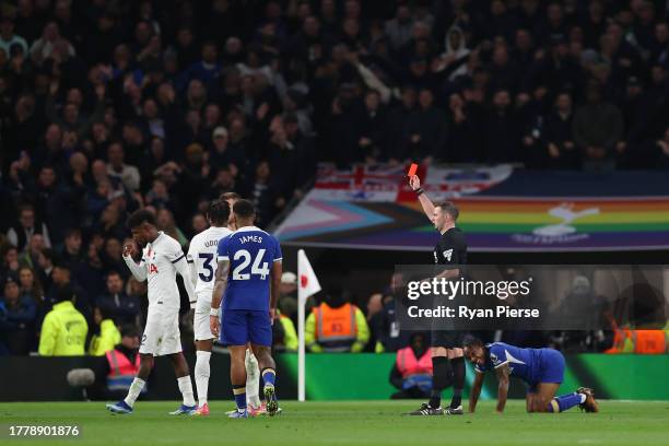 Referee Michael Oliver shows a red card to Destiny Udogie of Tottenham Hotspur after a foul on Raheem Sterling of Chelsea during the Premier League...