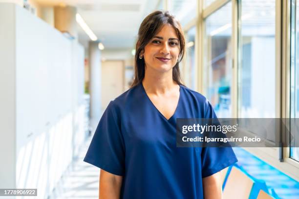 portrait of an attractive dark-haired nurse in the hallway of the hospital or medical center, medical team of the medical clinic - executivo chefe de operações - fotografias e filmes do acervo