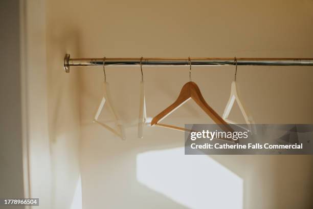 conceptual image of empty wooden coat hangers in a closet - sales decline stock pictures, royalty-free photos & images