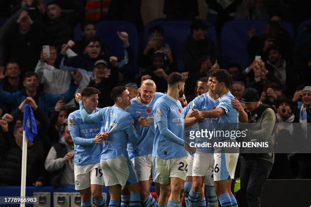 Manchester City's Norwegian striker Erling Haaland celebrates with teammates after scoring their third goal during the English Premier League...