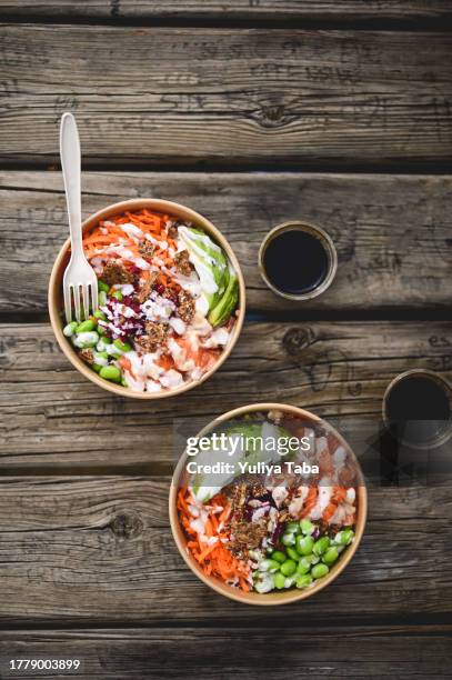 healthy poke bowls on a wooden table with soy sauce. - salad bowl stock pictures, royalty-free photos & images