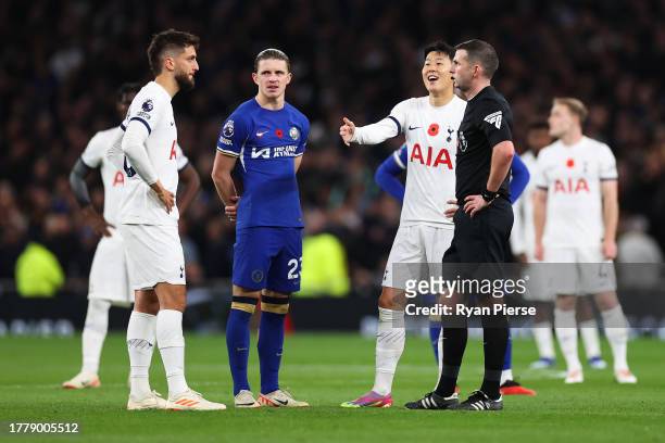 Referee Michael Oliver communicates with the VAR officials as they review the goal of Son Heung-Min of Tottenham Hotspur which was later disallowed...