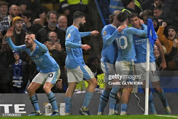 Manchester City's Spanish midfielder Rodri celebrates with teammates after his deflected shot makes it 3-4 to City during the English Premier League...