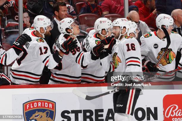 Teammates congratulate Jason Dickinson of the Chicago Blackhawks after he scored a first period goal against the Florida Panthers at the Amerant Bank...